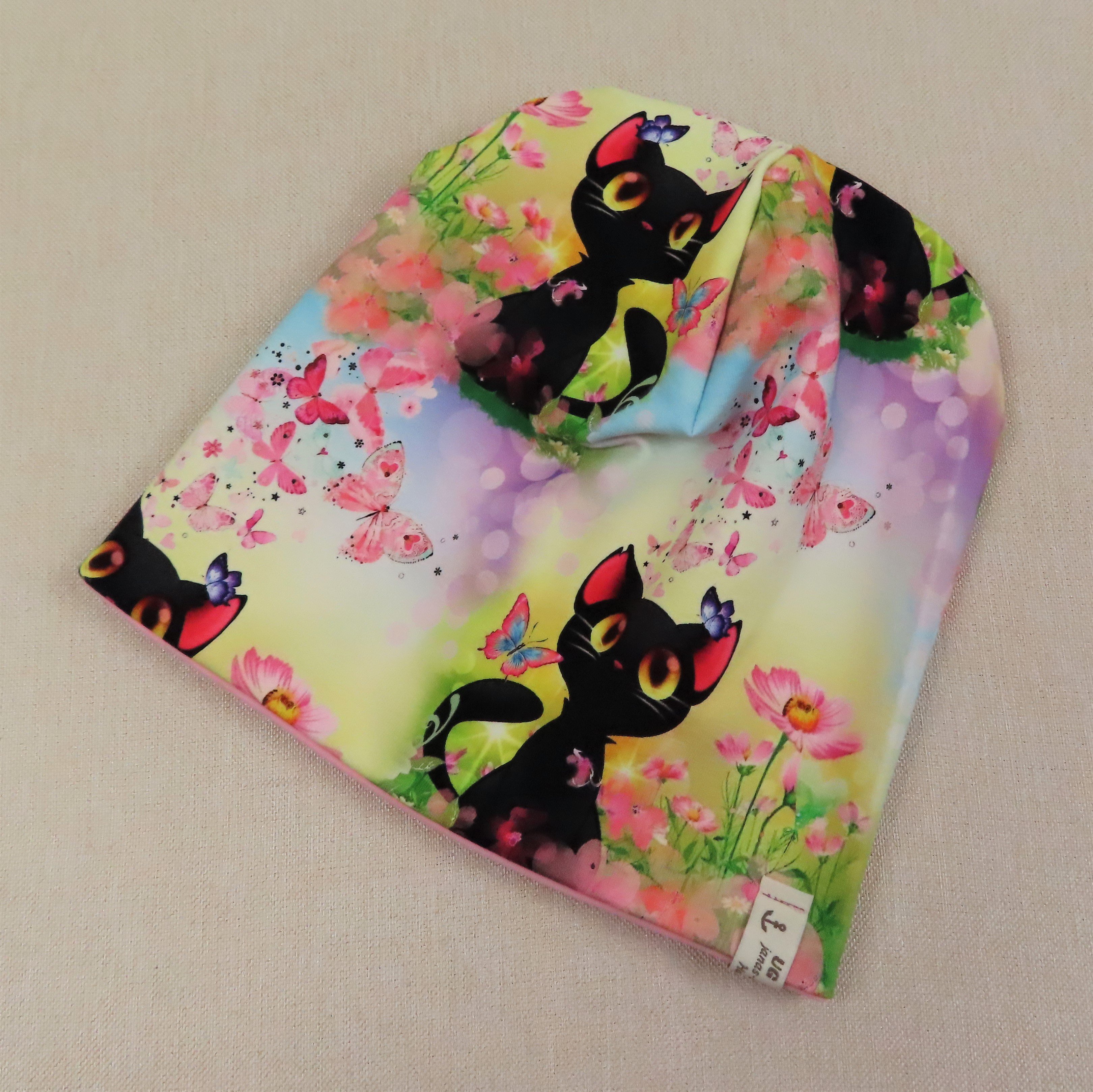 Beanie-Set, schwarzes Kätzchen auf einer Wiese