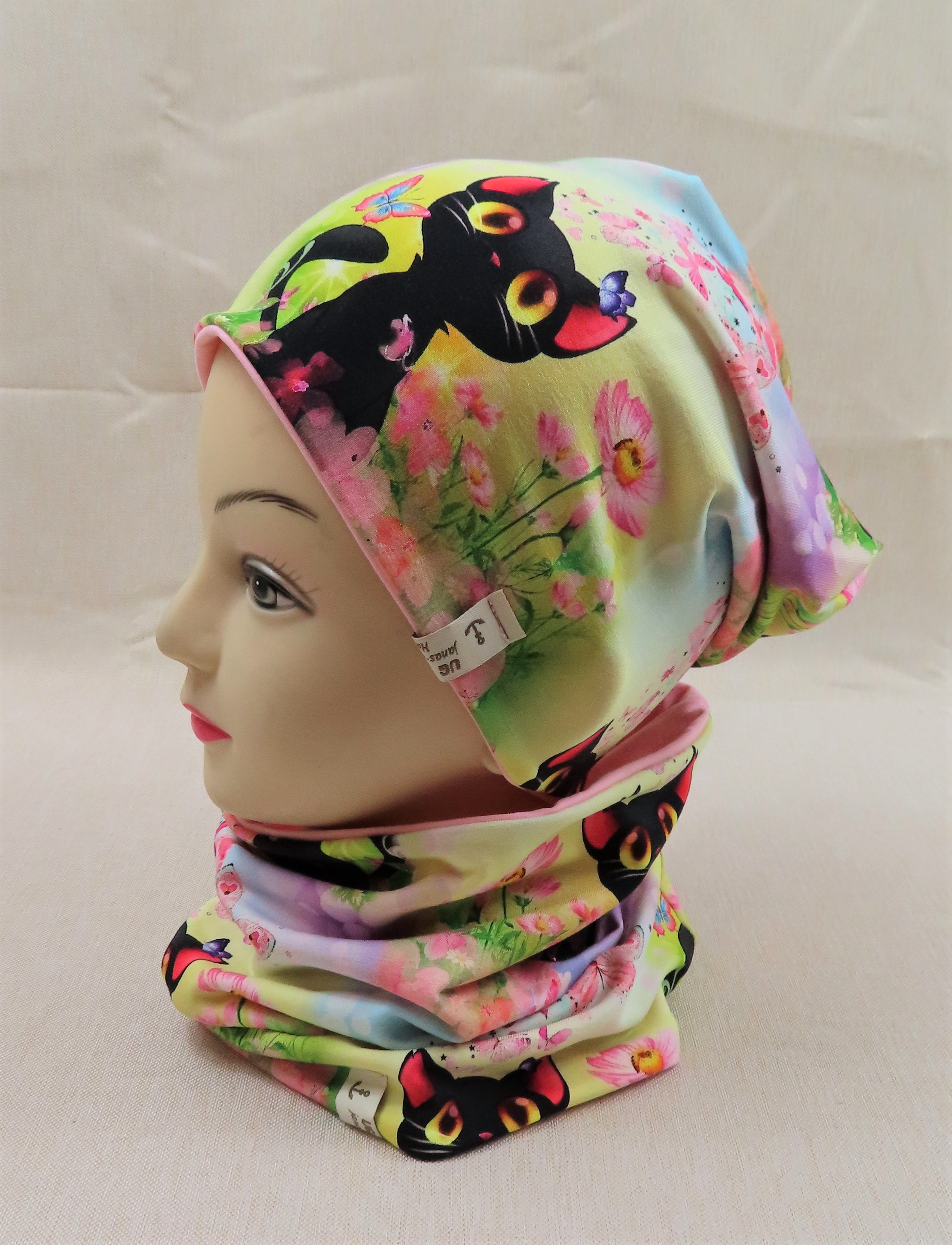 Beanie-Set, schwarzes Kätzchen auf einer Wiese